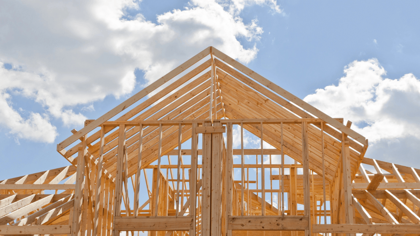 Timber house framing under construction representing early price-check quotes and builder budgeting stages.