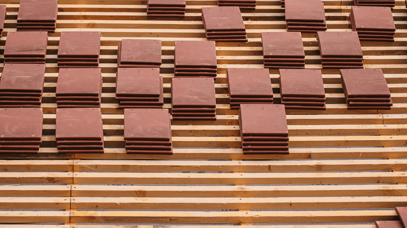 Stacks of roof tiles laid out on timber battens at a residential construction site